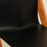 Black chair with wooden frame on a beige background