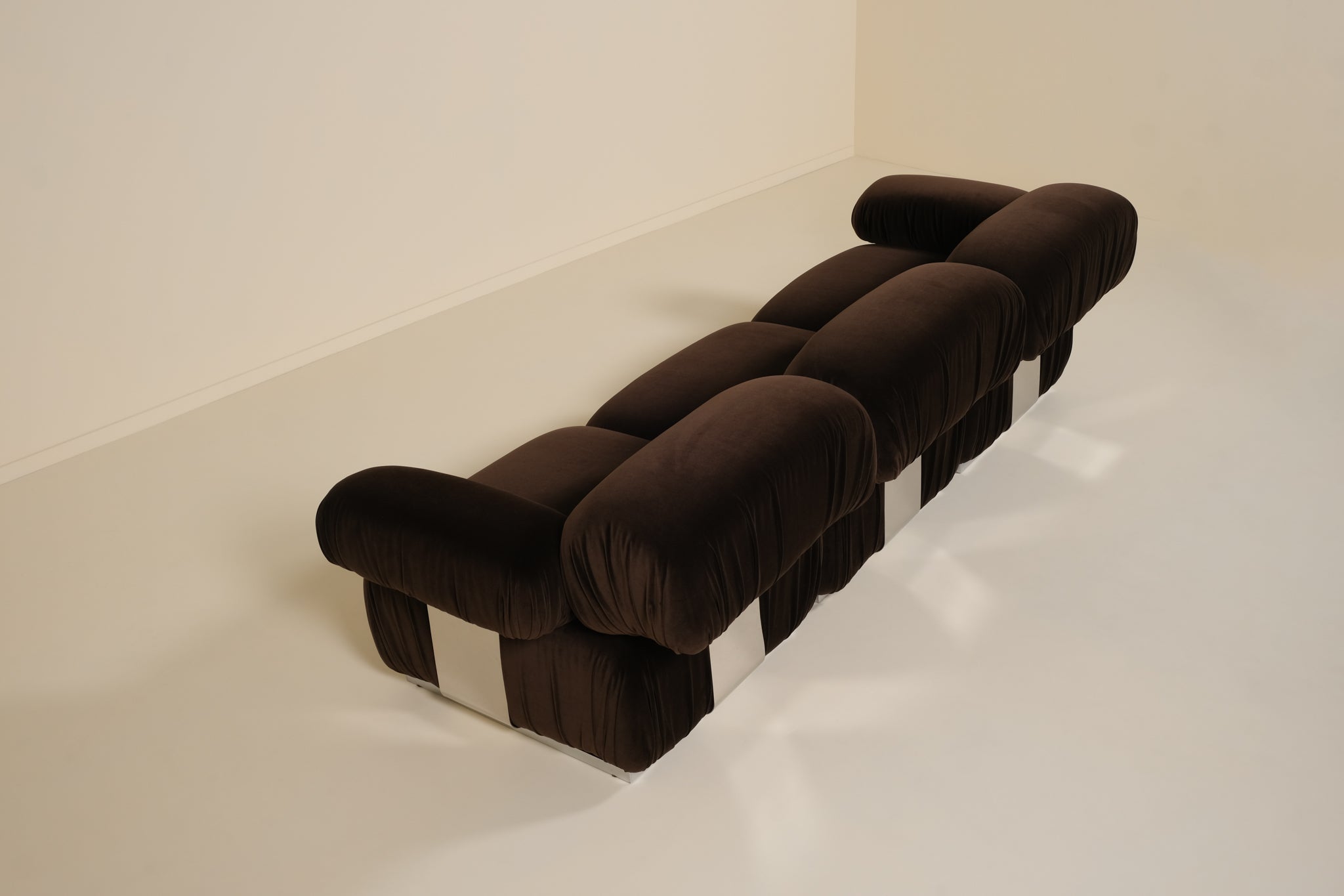 Brown sofa with a checkered pattern on a white floor and wall