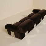 Brown sofa with a checkered pattern on a white floor and wall