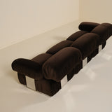 Brown sofa with a checkered pattern on a white floor and wall