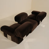 Brown modular sofa on a white floor with a white wall background