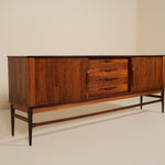 Wooden sideboard with drawers against a beige wall
