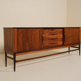 Wooden sideboard with drawers against a beige wall