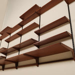 Wooden wall shelf with multiple shelves on a plain wall