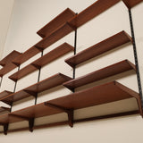 Wooden wall shelf with multiple shelves on a plain wall