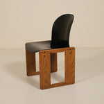 Chair with wooden frame and black seat on a beige background