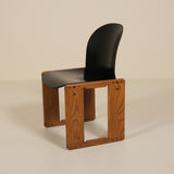 Chair with wooden frame and black seat on a beige background
