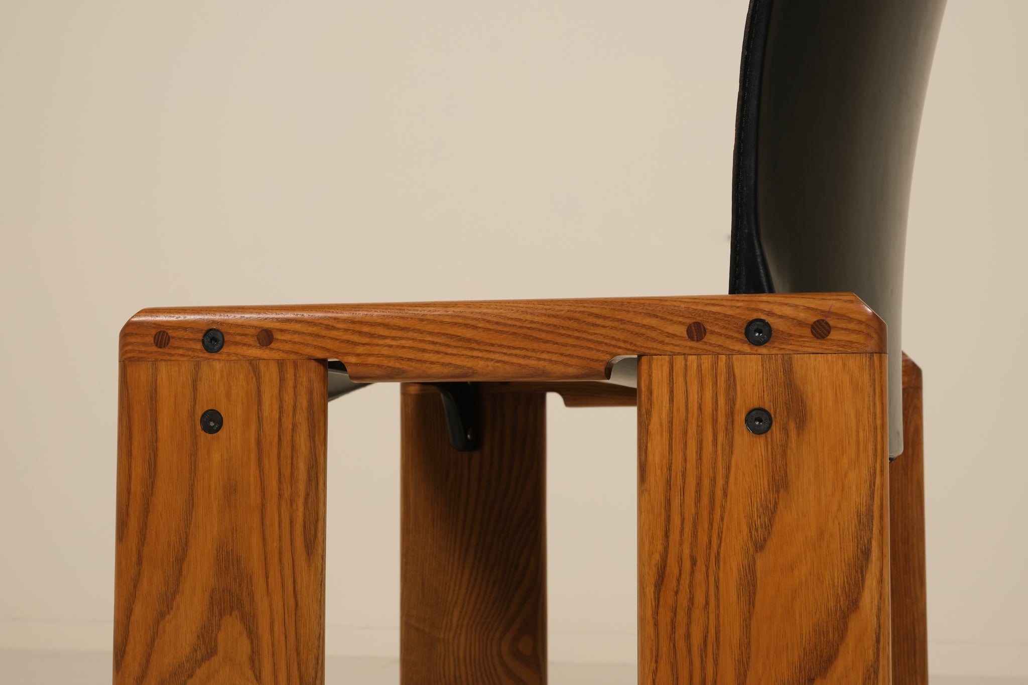 Wooden chair with a black seat on a beige background
