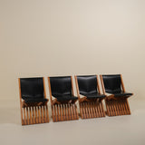 Four black leather chairs with wooden frames arranged in a row on a beige background