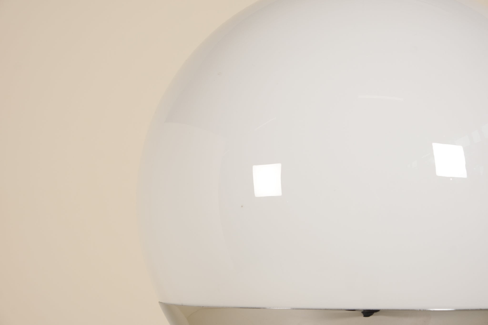 Close-up of a white spherical lamp with a beige background